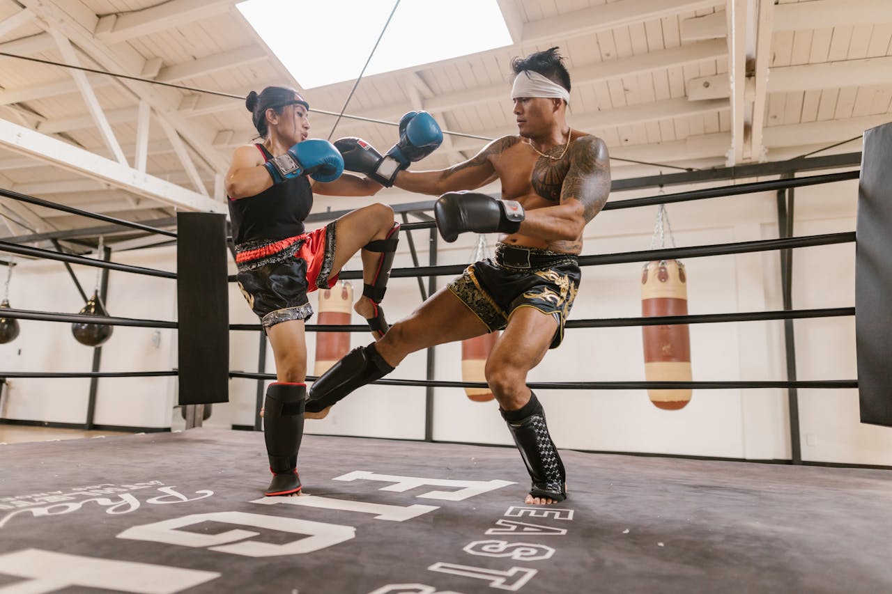 Two athletes practicing martial arts in a ring, showcasing powerful techniques.