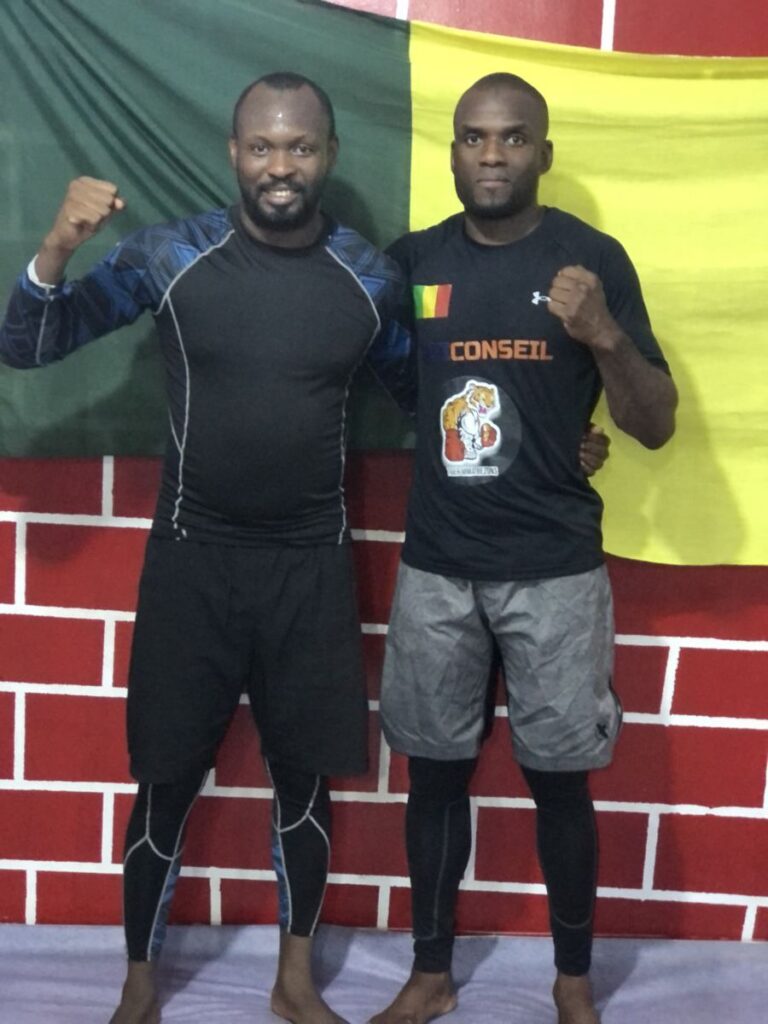 Deux coachs de l’AFS Academy devant le drapeau du Mali